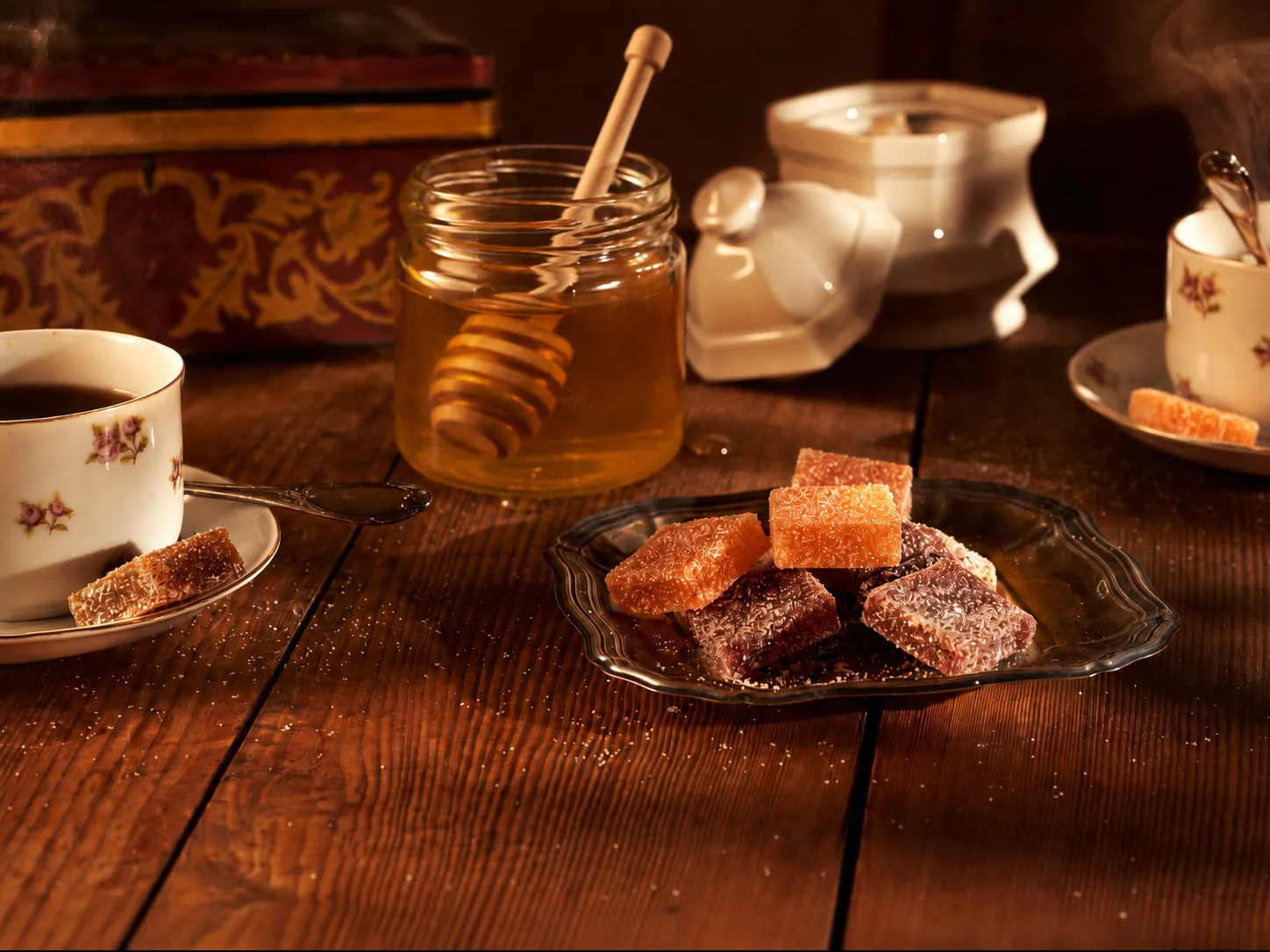Pâtes de fruits au miel et pot de miel sur une table en bois